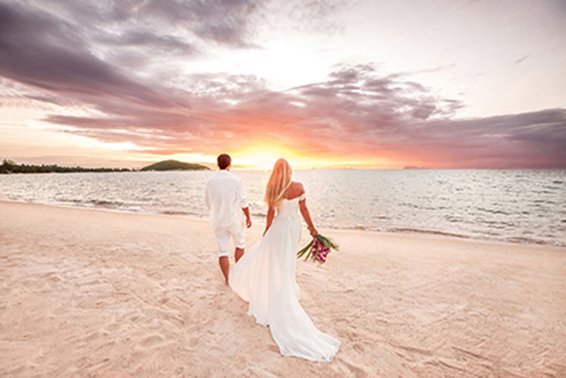 Married couple strolling along the beach 