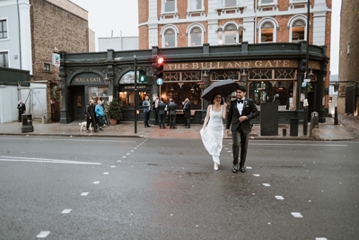 Bride and Groom crossing road outside the Bull and Gate