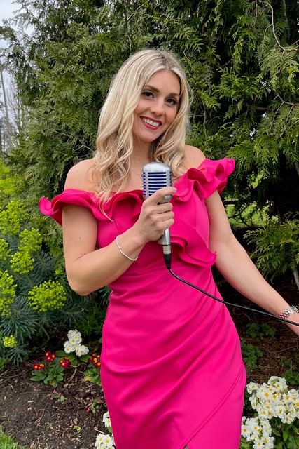 Lady singing into 50s style microphone in red dress